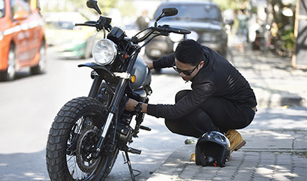 Guy working on motorcycle in the street