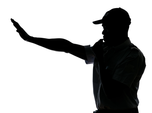 traffic cop with arm extended to stop traffic