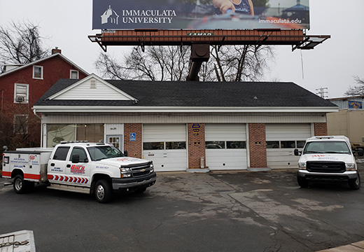 image of Bill's emergency towing shop with 2 service trucks in front of it