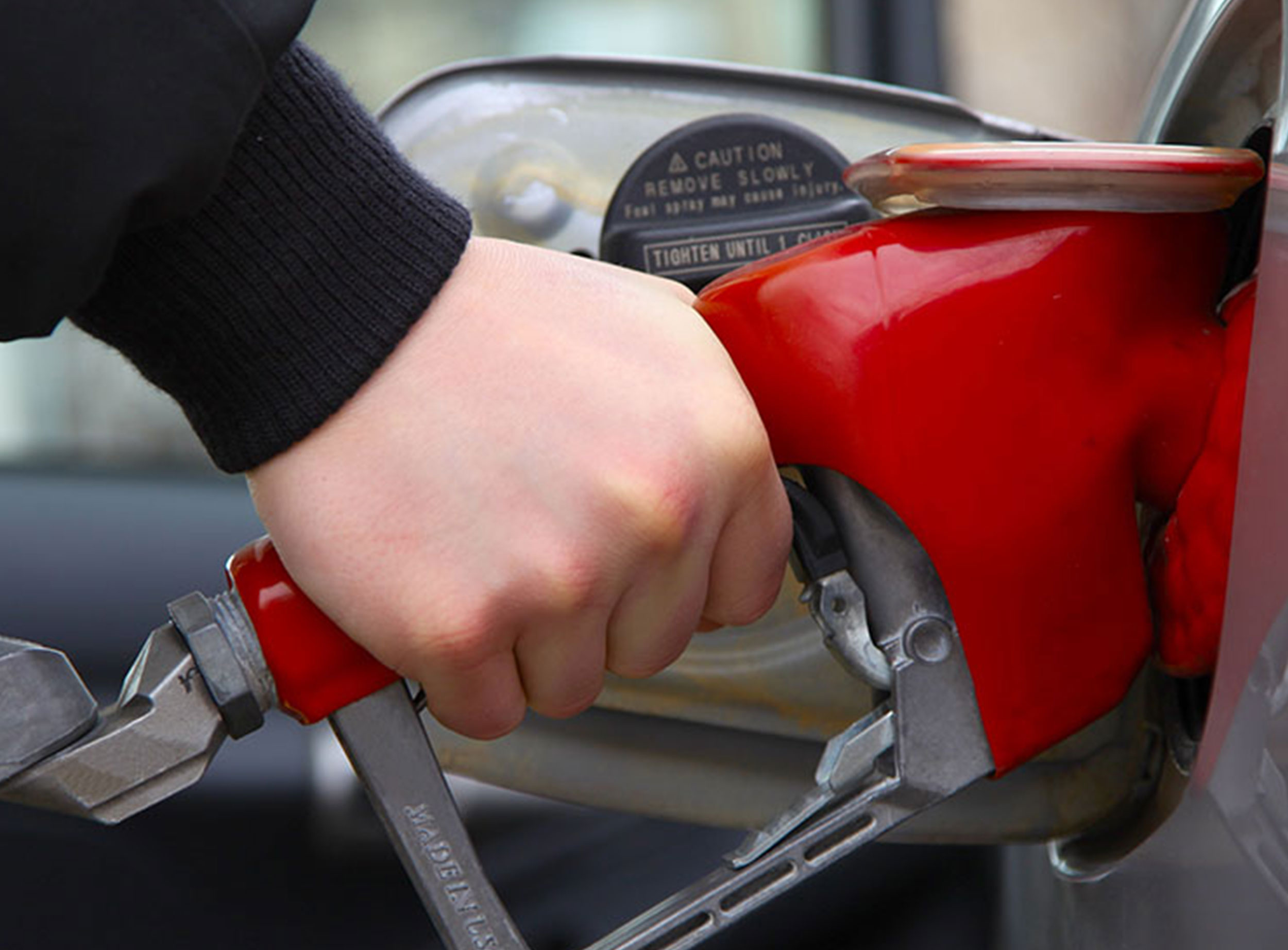 image of hand pumping gas into vehicle