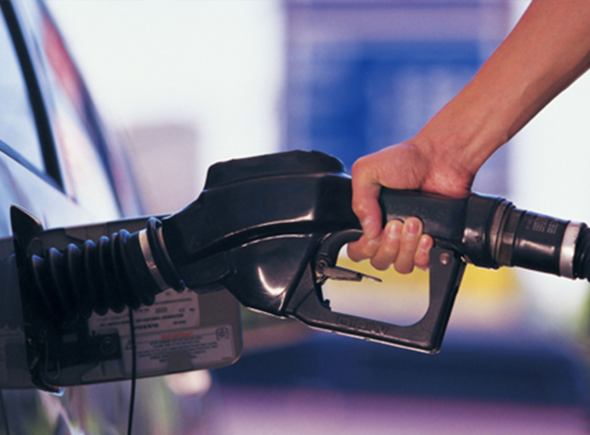 image of man's hand pumping gas into vehicle