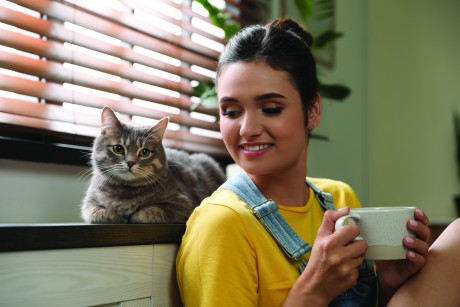 image of woman looking at her cat lovingly while holding a coffee cup