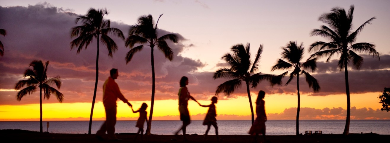 people walking on beach in Hawaii at sunset
