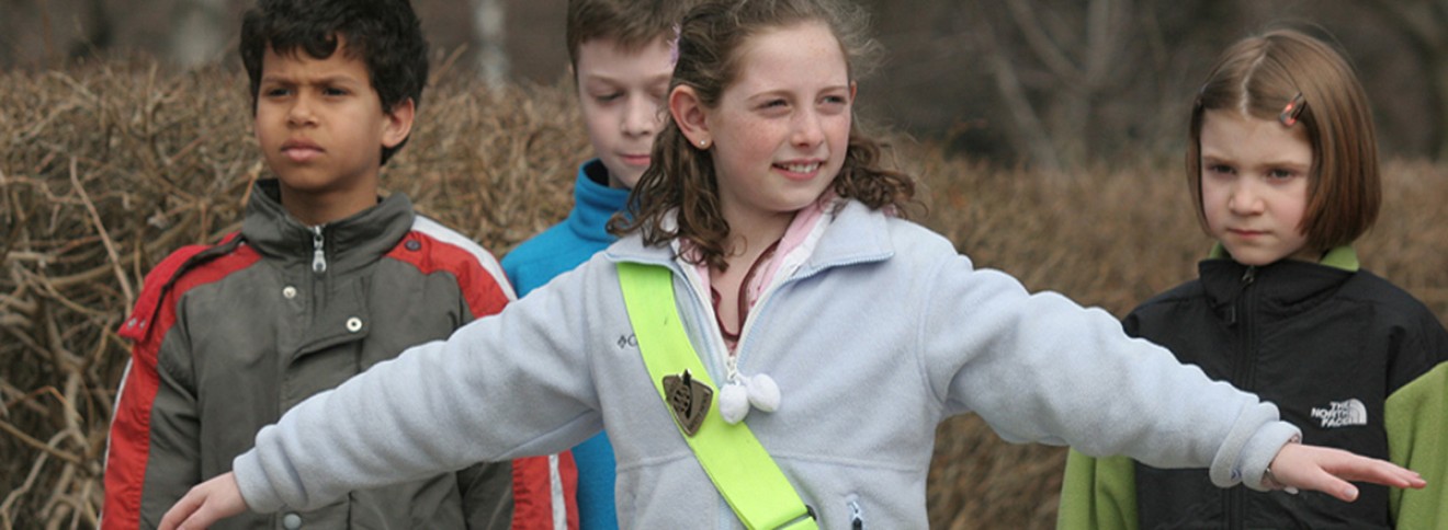 adolescent crossing guard blocking children from crossing street