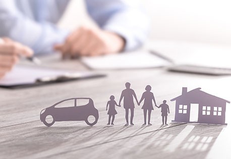 image of silhouetted car, people, and house with insurance agent in the background